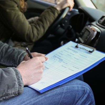 Moniteur agréé aidant une jeune femme à réussir son permis